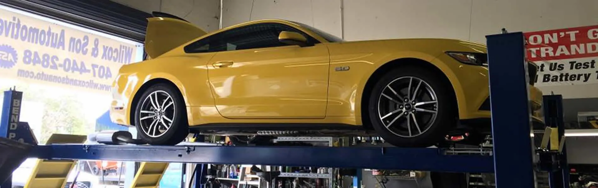Yellow Mustang GT on the lift